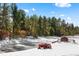 Scenic view of red tractor, pond and barn with a treed landscape at 367 Sandy Hollow Trl, Franktown, CO 80116