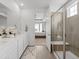 Bright bathroom featuring double sinks, white cabinets, and a glass-enclosed shower at 15788 Xanthia Way, Thornton, CO 80602