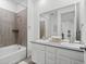 Bright bathroom featuring double sinks, modern fixtures, and a shower over tub with tile surround at 15788 Xanthia Way, Thornton, CO 80602