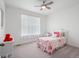 Bright and cozy bedroom features a ceiling fan, pink accents, and a window providing natural light at 15788 Xanthia Way, Thornton, CO 80602