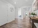 Bright entryway features wood floors, white walls, and decorative accents throughout the home's open floor plan at 15788 Xanthia Way, Thornton, CO 80602