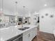 Open-concept kitchen features quartz countertops, stainless appliances, and seamlessly connects to the living area at 15788 Xanthia Way, Thornton, CO 80602