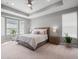Bright main bedroom featuring a tray ceiling, large windows, and neutral décor at 15788 Xanthia Way, Thornton, CO 80602