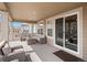 Spacious covered patio with plush seating, offering a comfortable outdoor living space at 15788 Xanthia Way, Thornton, CO 80602