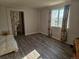 This bedroom features wood-look floors, bright natural light, and an open doorway to the bathroom at 2746 E 132Nd Pl, Thornton, CO 80241
