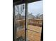 View of the deck and fenced back yard through sliding glass doors on a snowy day at 2746 E 132Nd Pl, Thornton, CO 80241