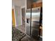 Bright kitchen with a large stainless steel refrigerator, adjacent to the entryway and stairs at 2746 E 132Nd Pl, Thornton, CO 80241