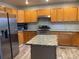 Updated kitchen features granite countertops, a stainless steel fridge and range, and a kitchen island at 2746 E 132Nd Pl, Thornton, CO 80241