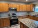 Kitchen featuring an island, stainless steel range and granite counters and wooden cabinetry at 2746 E 132Nd Pl, Thornton, CO 80241