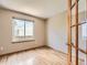 Bright, sunlit bedroom showcasing hardwood floors, a large window, and neutral wall tones at 7659 Lebrun Ct, Lone Tree, CO 80124