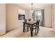 Elegant dining room with a wooden table set for four, complemented by modern lighting and decor at 7659 Lebrun Ct, Lone Tree, CO 80124