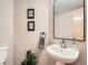 Stylish powder room featuring a pedestal sink, decorative mirror, and contemporary fixtures at 7659 Lebrun Ct, Lone Tree, CO 80124