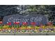 Community entrance sign for Carriage Club with colorful flowerbed at 7659 Lebrun Ct, Lone Tree, CO 80124