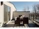 Cozy balcony with wicker furniture, a table, privacy walls, and a view of the surrounding neighborhood at 1322 Raleigh St, Denver, CO 80204