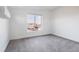 Minimalist bedroom with gray carpet, a large window offering neighborhood views, and neutral walls at 1322 Raleigh St, Denver, CO 80204