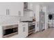 Modern kitchen featuring white cabinets, stainless steel appliances, and stylish herringbone backsplash at 1322 Raleigh St, Denver, CO 80204