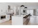 Modern white kitchen with stainless steel appliances, a large island with seating, and open access to the living area at 1322 Raleigh St, Denver, CO 80204