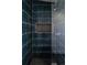 Modern shower featuring dark vertical tiles, a tiled niche, a hexagonal shower floor, and contemporary fixtures at 1322 Raleigh St, Denver, CO 80204