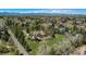 Scenic aerial view of a home nestled among mature trees with mountain views in the distance at 4480 S Franklin St, Cherry Hills Village, CO 80113