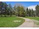 Scenic view of a winding driveway, lush lawn, and mature trees on the property at 4480 S Franklin St, Cherry Hills Village, CO 80113