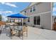 Spacious backyard with a dining table and a large blue umbrella at 3917 Starry Night Loop, Castle Rock, CO 80109