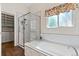 Bathroom featuring a separate glass shower and tub with decorative window at 6900 W Grant Ranch Blvd # 59, Littleton, CO 80123