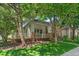 Angle view of charming home with a covered porch and well-maintained lawn, shaded by mature trees at 6900 W Grant Ranch Blvd # 59, Littleton, CO 80123