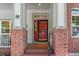 Inviting front porch with brick columns, house number 59, and a decorative front door with a storm door at 6900 W Grant Ranch Blvd # 59, Littleton, CO 80123