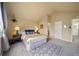 Spacious bedroom with a bed, neutral carpet, and an ensuite bathroom, offering comfort and convenience at 7072 Palisade Dr, Highlands Ranch, CO 80130