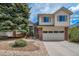 Inviting two-story home with brick accents, large tree, and well-maintained front yard and two car garage at 7072 Palisade Dr, Highlands Ranch, CO 80130