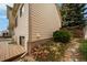 Exterior shot shows a beige home corner featuring a small window above the foundation and stone landscaping at 7072 Palisade Dr, Highlands Ranch, CO 80130