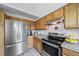 Well-lit kitchen equipped with stainless steel appliances, wooden cabinets, and light granite countertops at 7072 Palisade Dr, Highlands Ranch, CO 80130