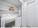 Functional laundry room equipped with a washer, dryer, and storage shelves at 7072 Palisade Dr, Highlands Ranch, CO 80130
