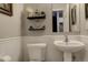Charming half bathroom boasting a pedestal sink, wainscoting, and decorative shelving at 841 Crisman Dr # 9, Longmont, CO 80501