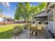 Private backyard featuring a patio with dining set, lush lawn, and mature trees at 14625 Vine St, Thornton, CO 80602