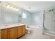 Bright bathroom featuring double sinks, soaking tub, and separate glass enclosed shower at 14625 Vine St, Thornton, CO 80602