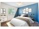 Stylish bedroom with white and blue accent wall, large window, and modern furnishings at 14625 Vine St, Thornton, CO 80602