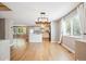 Open dining area with hardwood floors connecting to a well lit kitchen at 14625 Vine St, Thornton, CO 80602
