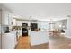 Eat-in kitchen boasts white cabinets, an island, black appliances, and wood flooring, flowing into dining at 14625 Vine St, Thornton, CO 80602