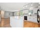 Bright kitchen featuring an island, white cabinets, stainless steel sink, and modern lighting at 14625 Vine St, Thornton, CO 80602