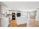 Modern kitchen with white cabinets, an island, and newer appliances with wood grain flooring at 14625 Vine St, Thornton, CO 80602