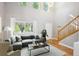 Bright living room with vaulted ceiling, large windows, a comfortable sofa, and a staircase at 14625 Vine St, Thornton, CO 80602