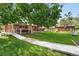 Lush backyard featuring a large tree providing ample shade, a wooden deck, and an access ramp for outdoor enjoyment at 3380 S Ogden St, Englewood, CO 80113