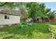 Large backyard with lush grass, mature trees, and an outdoor seating area with a fire pit at 3380 S Ogden St, Englewood, CO 80113
