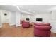 Finished basement area with a mirror, red leather armchairs, wood flooring and a flat screen tv at 3380 S Ogden St, Englewood, CO 80113