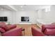 Finished basement area with a daybed, red leather armchairs, wood flooring and a flat screen tv at 3380 S Ogden St, Englewood, CO 80113