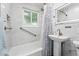 Bright bathroom with white marble tile, shower-tub combination, and modern fixtures at 3380 S Ogden St, Englewood, CO 80113