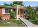 Welcoming front entrance featuring a brick facade, ramp access, and manicured greenery at 3380 S Ogden St, Englewood, CO 80113