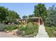 Charming brick home featuring a beautifully landscaped front yard with vibrant flowers and lush greenery at 3380 S Ogden St, Englewood, CO 80113