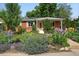 Inviting brick home with a well-manicured lawn and colorful flower beds enhancing its curb appeal at 3380 S Ogden St, Englewood, CO 80113